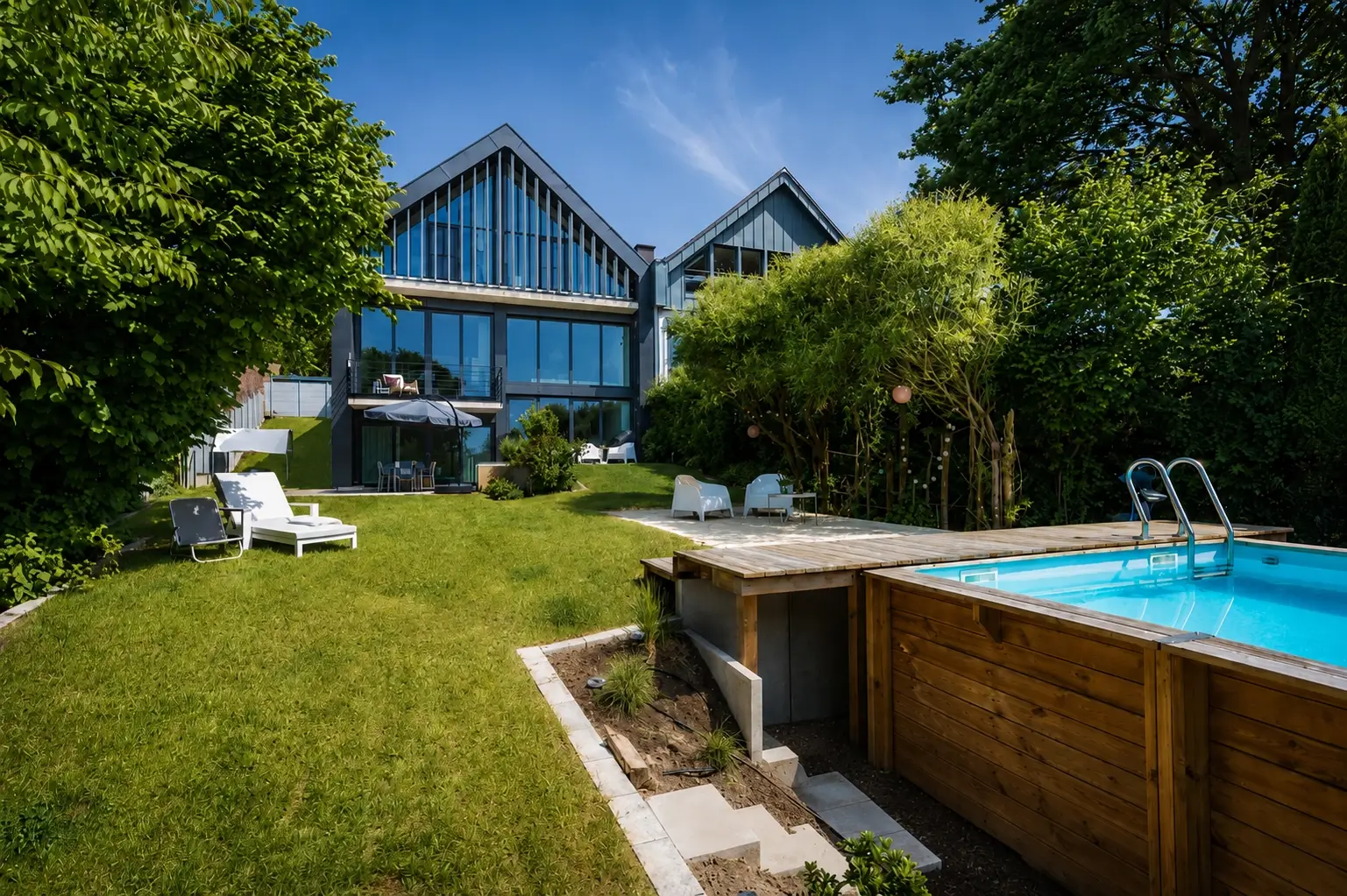 Blick vom Garten auf das Haus und den Pool